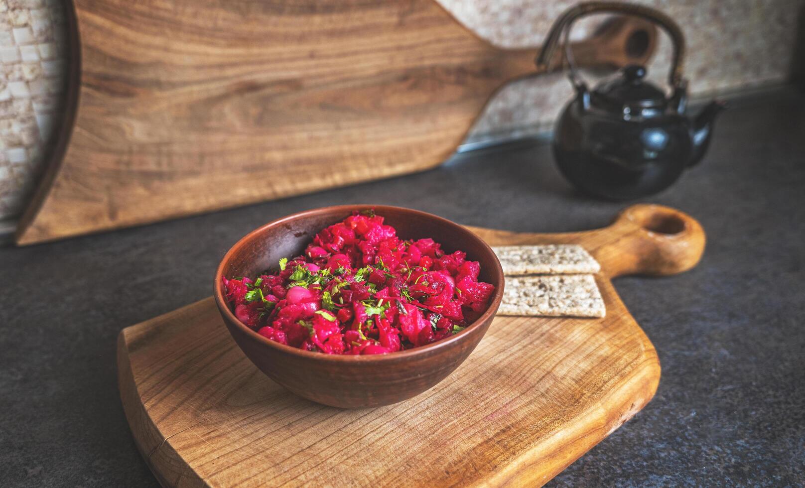 Rustic kitchen scene with beet salad in a wooden bowl and healthy crispbread. Clean composition with natural textures and organic colors photo