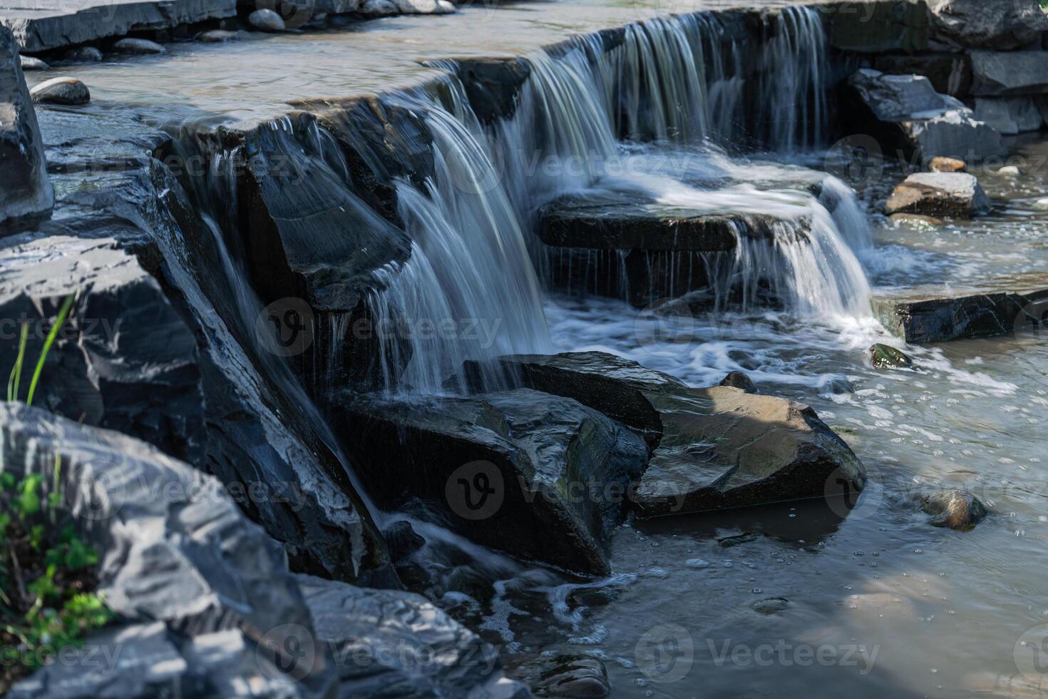 A Serene Waterfall Flowing Gracefully Over Rugged Rocky Terrain Offering Natural Beauty photo