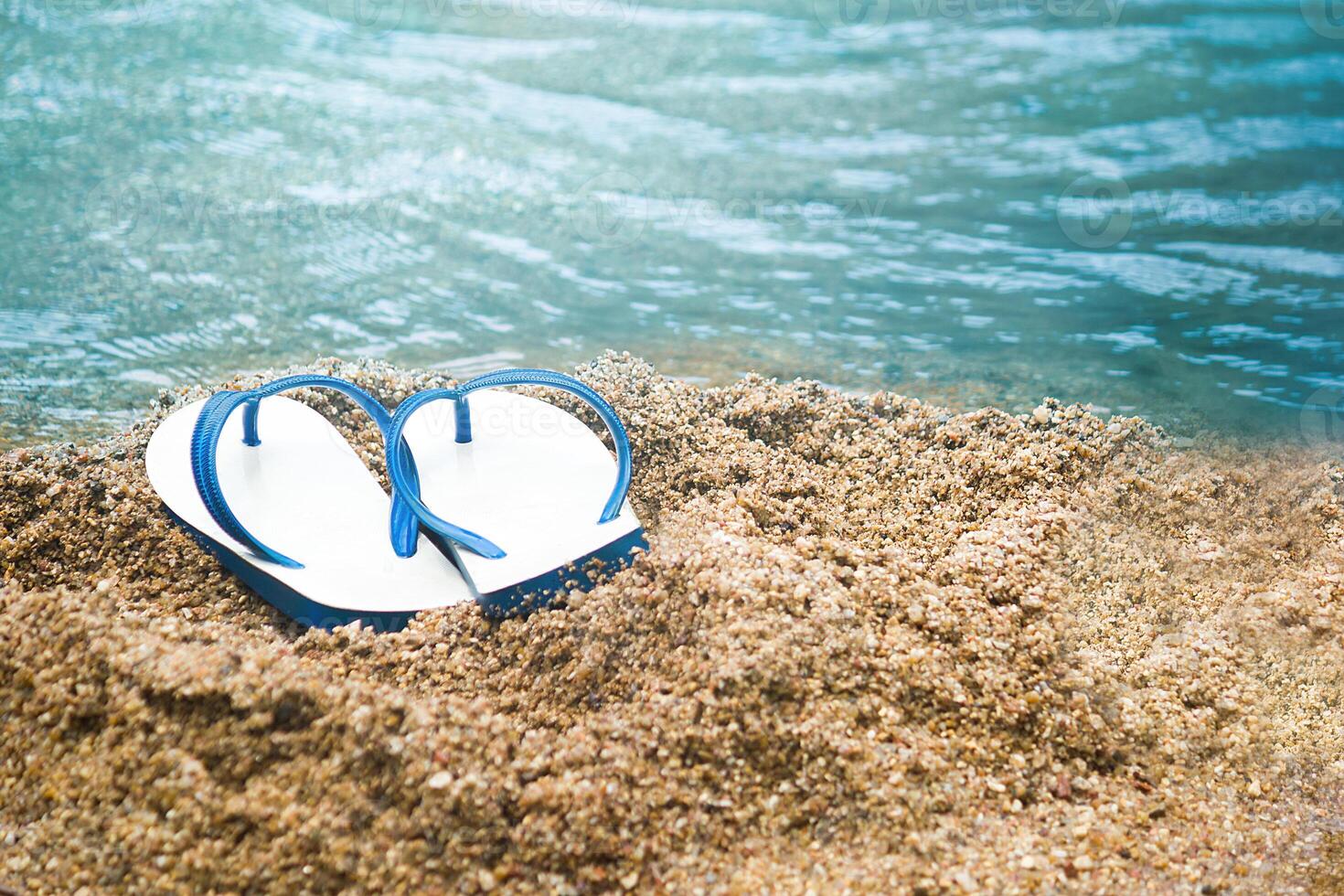 white and blue sandal on the sand beach, Summer holiday and vacation concept. photo