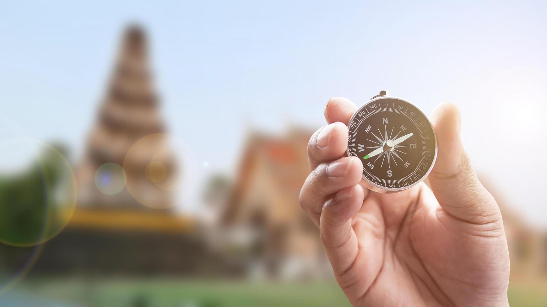 compass in hand on thai temple blur background with lighting flare. photo