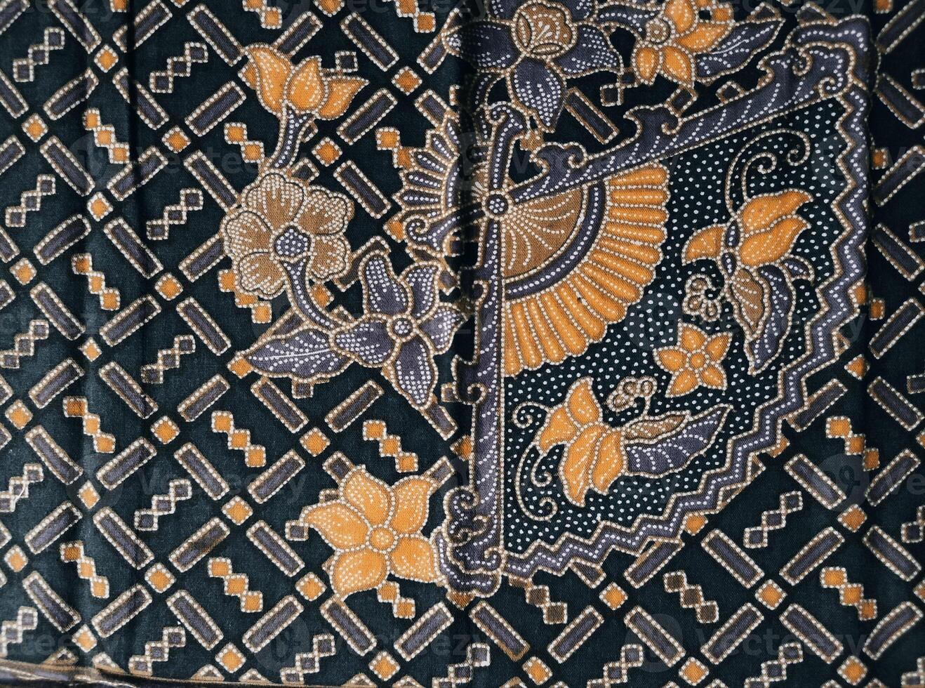 a black and yellow patterned fabric with a flower design photo