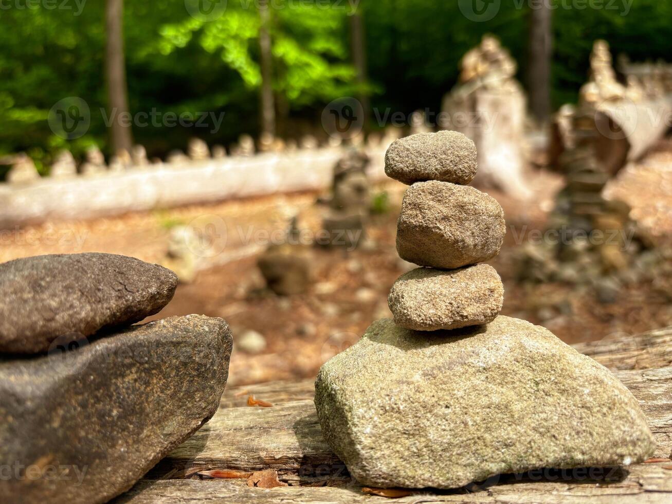 Pyramids are made of small stones in mountainous terrain. Close-up of a stone pyramid standing on a log. photo