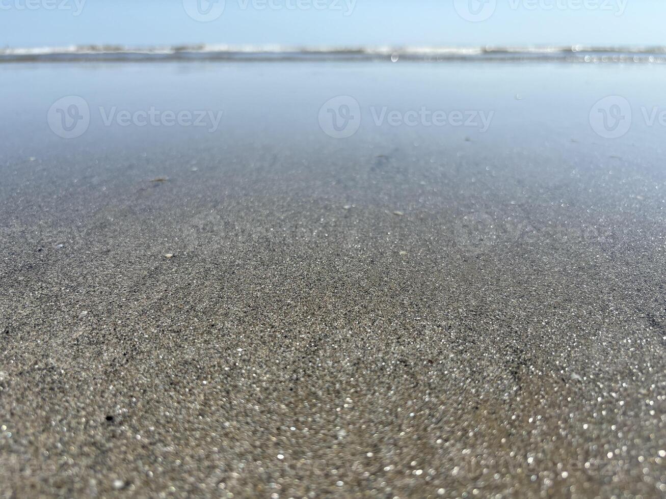 Sparkling sand on a shallow in the Ligurian Sea. Panorama of the seashore with a close-up of the sand. photo