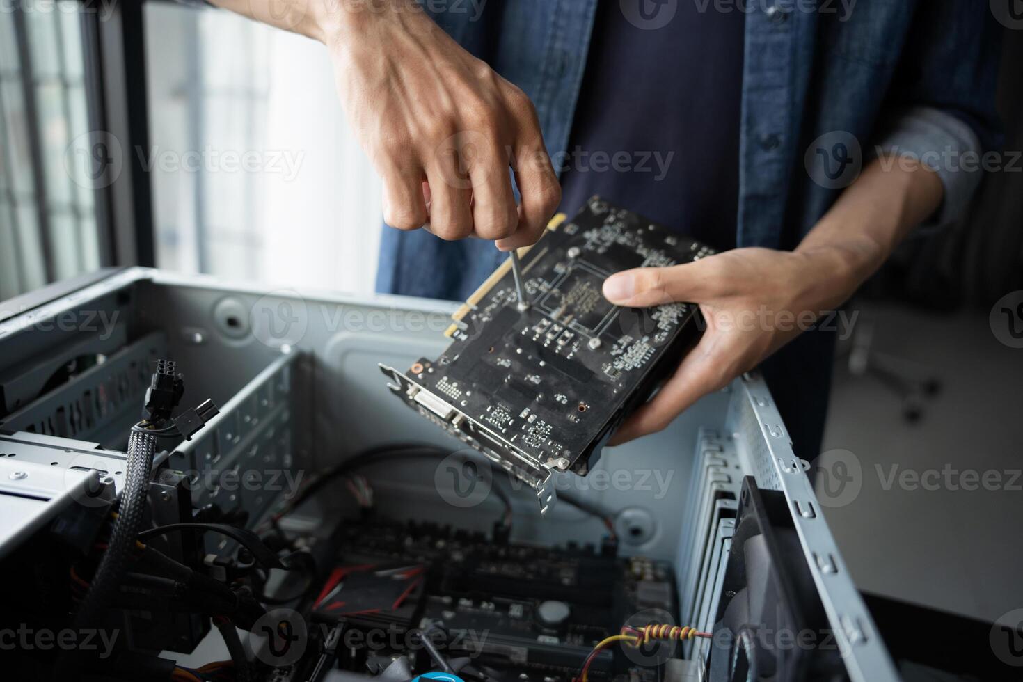 a Engineer installing Hardware holding a computer motherboard photo