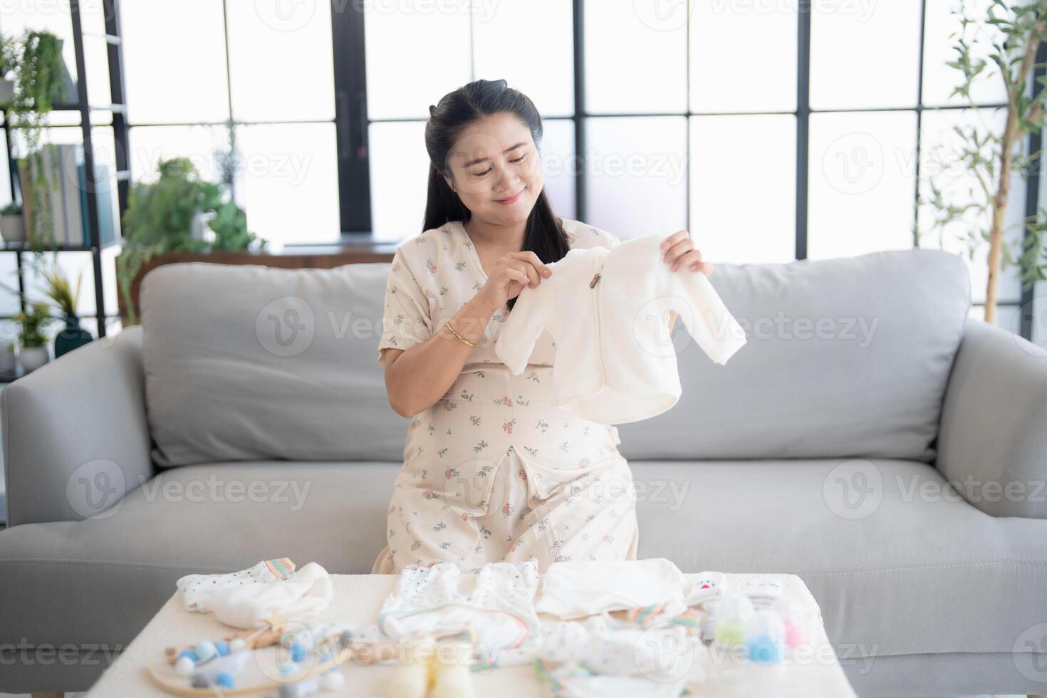 a Pregnant woman is sitting on a couch with her baby photo
