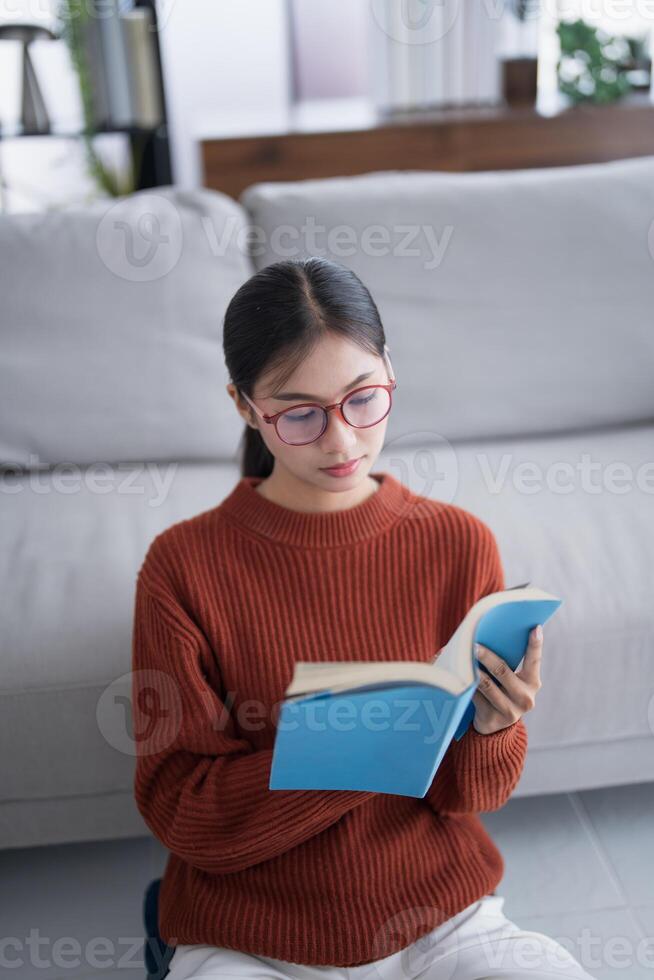 a woman wearing glasses is reading a book photo