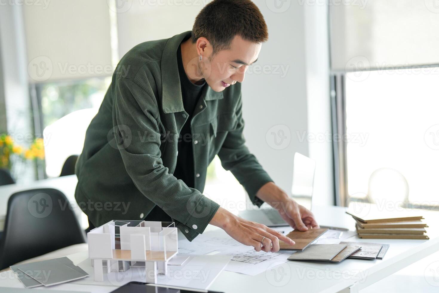 a Architecture Man working on a project at a desk photo
