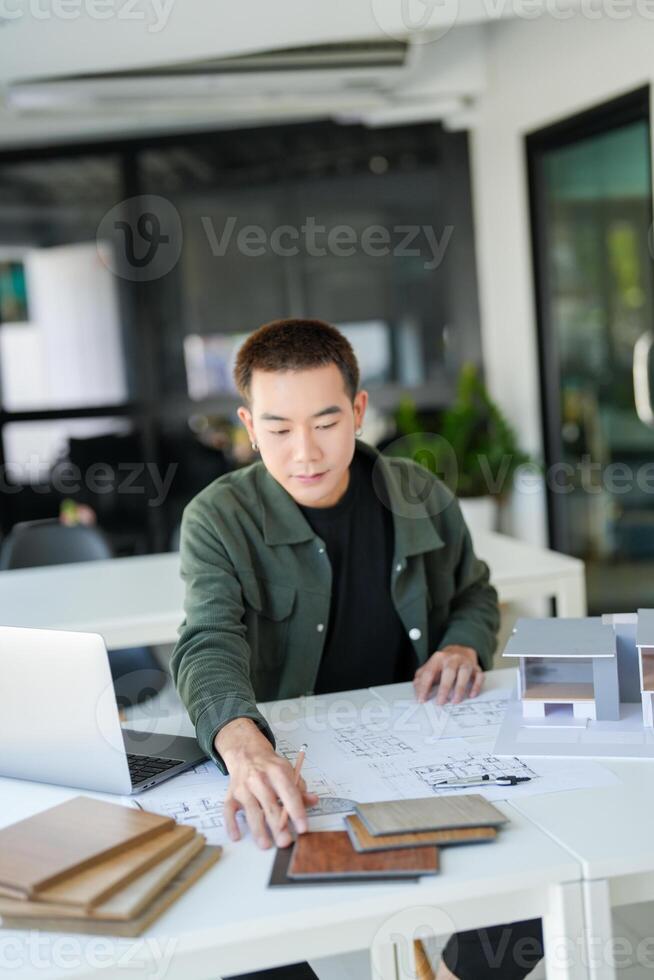 a business man sitting at a table with a laptop and papers photo
