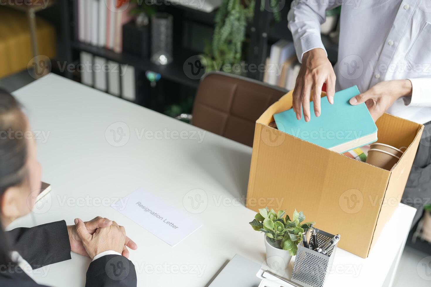 Business man sending resignation letter and packing Stuff carrying business cardboard box Change of job or fired from company resign. photo