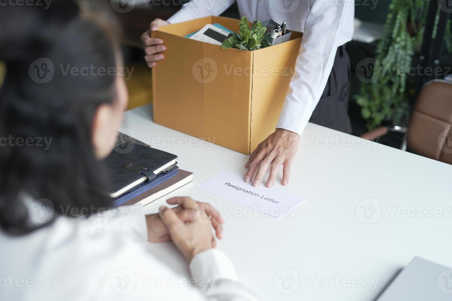 Business man sending resignation letter to boss Holding Stuff Resign Depress or carrying cardboard box by desk in office photo