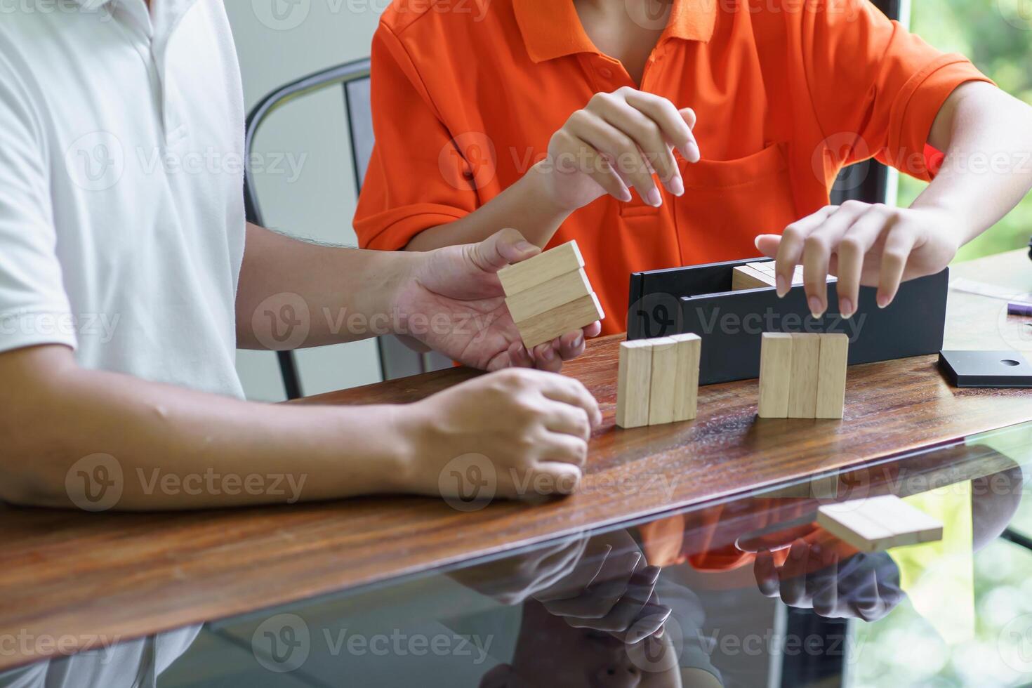 Asian father and son playing wood blocks game Carefree kid playing wood blocks building constructor from blocks with father at home. photo