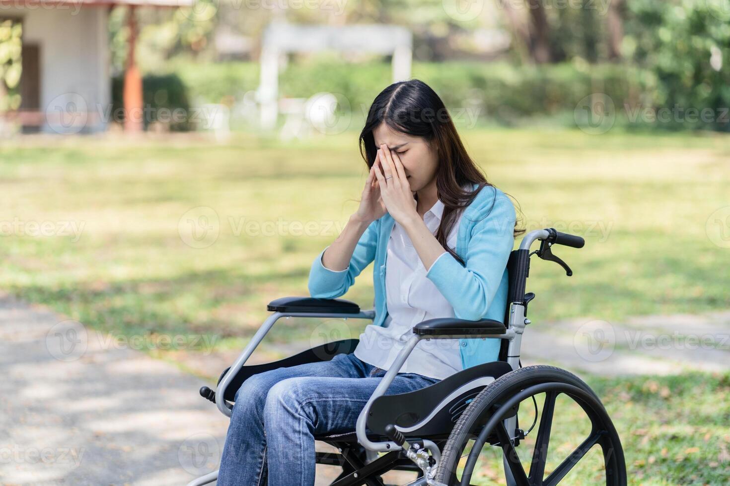Depressed sad woman in a wheelchair in park. photo