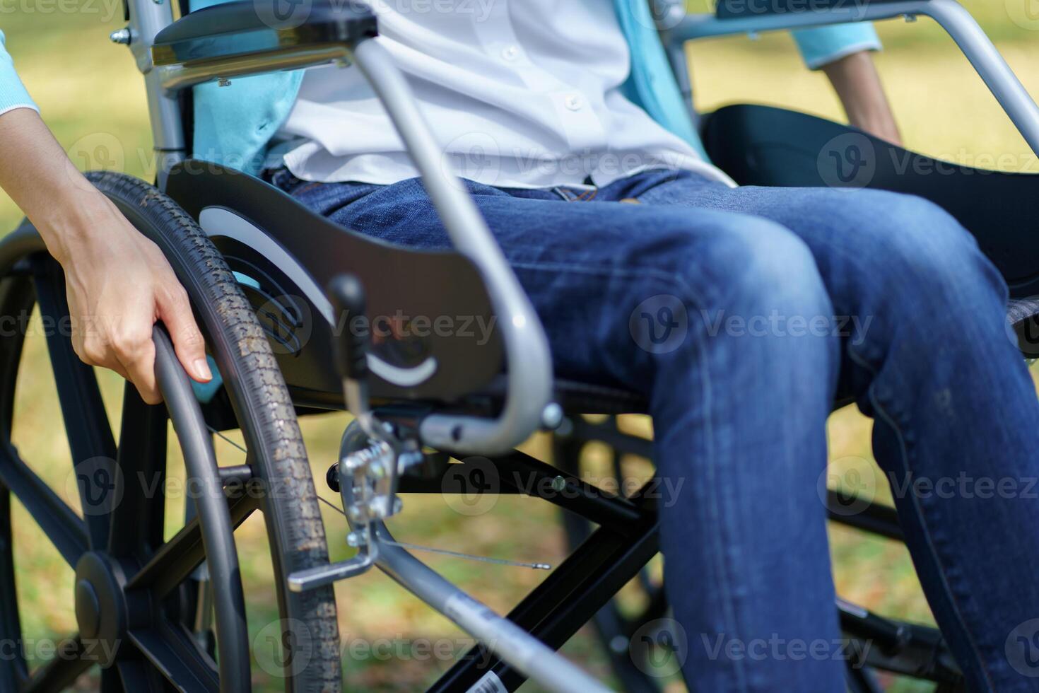 Depressed sad woman in a wheelchair in park photo