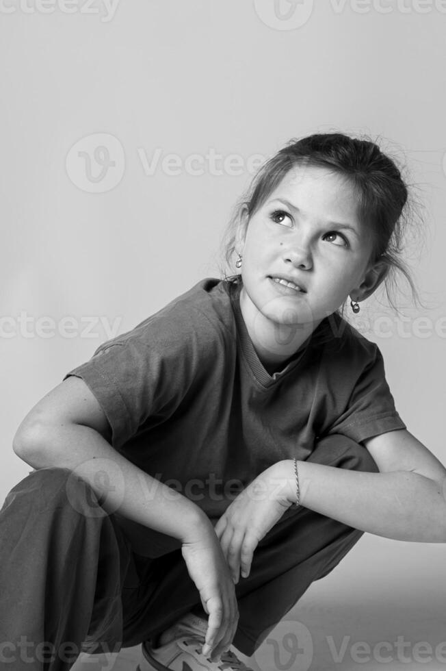 Monochrome close up of a girls face in studio lighting, eyes expressive, hair gently falling over her shoulder. The mood is serene and timeless. photo