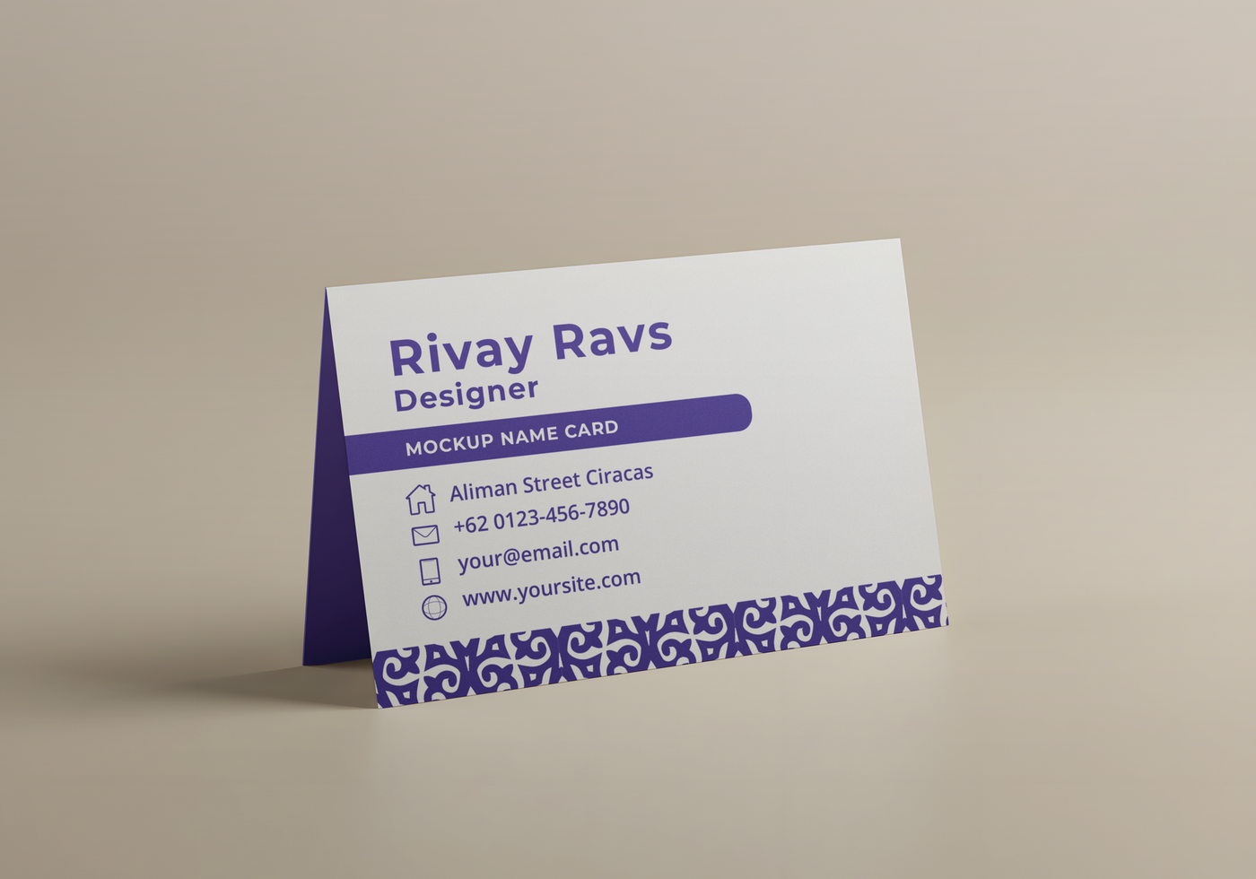 A mockup of Rivay Ravs designer name card stands on a beige surface psd
