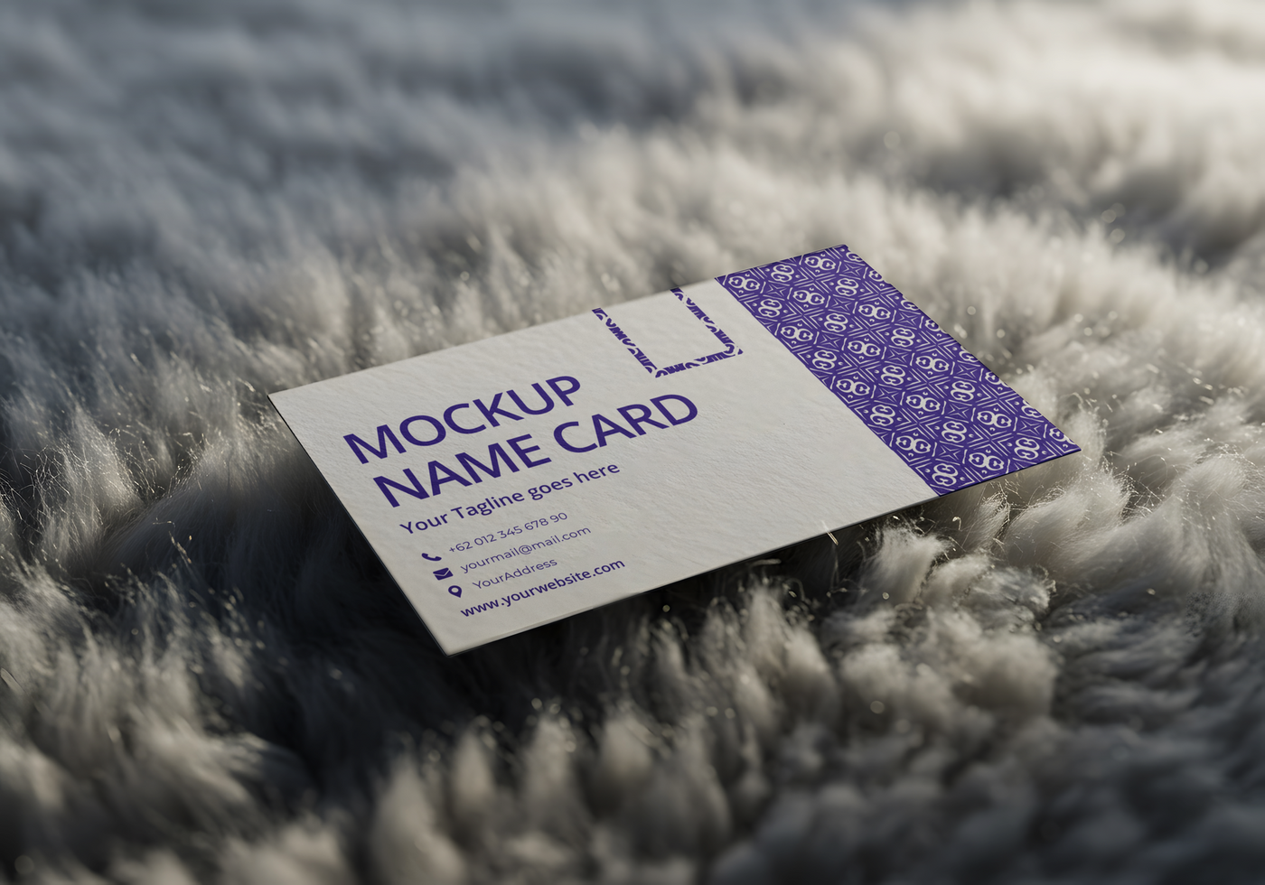 A mockup name card rests on a fluffy gray surface psd