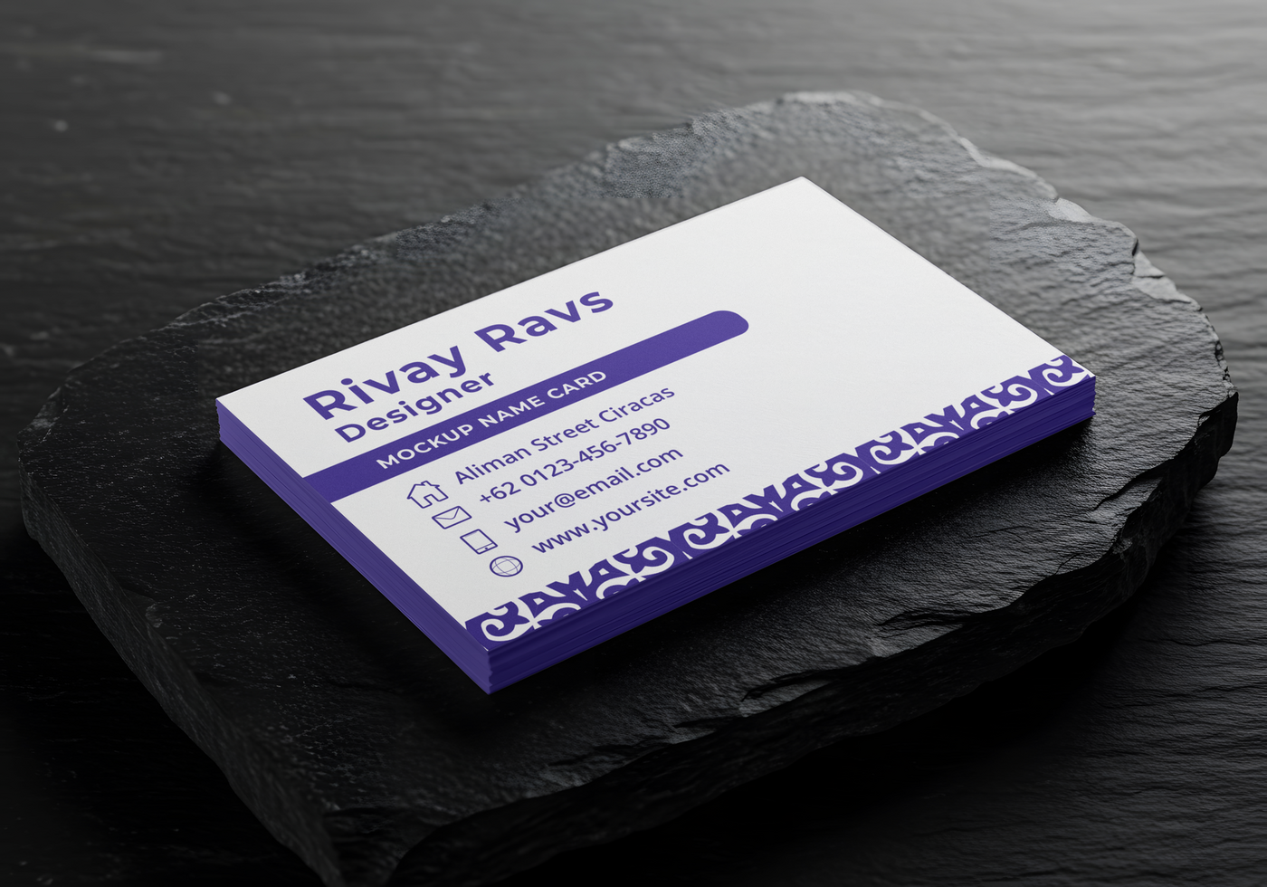 A stack of designer business cards rests on a dark stone surface psd