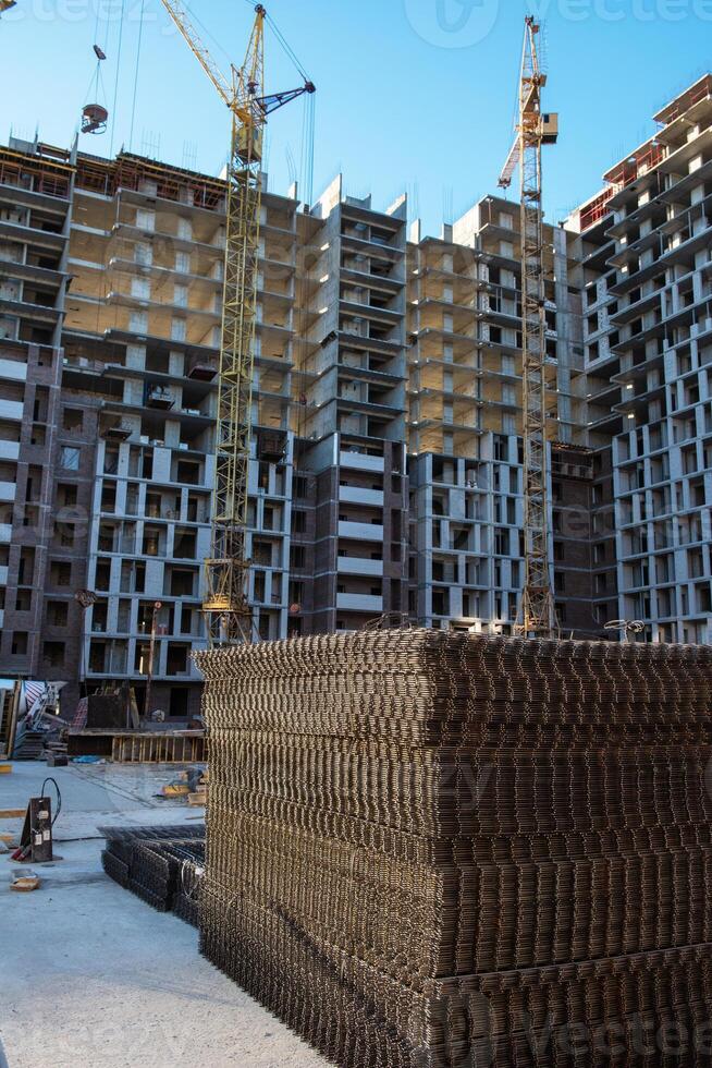 Ongoing construction of modern high-rise apartments with cranes, steel reinforcements, and unfinished structures. photo