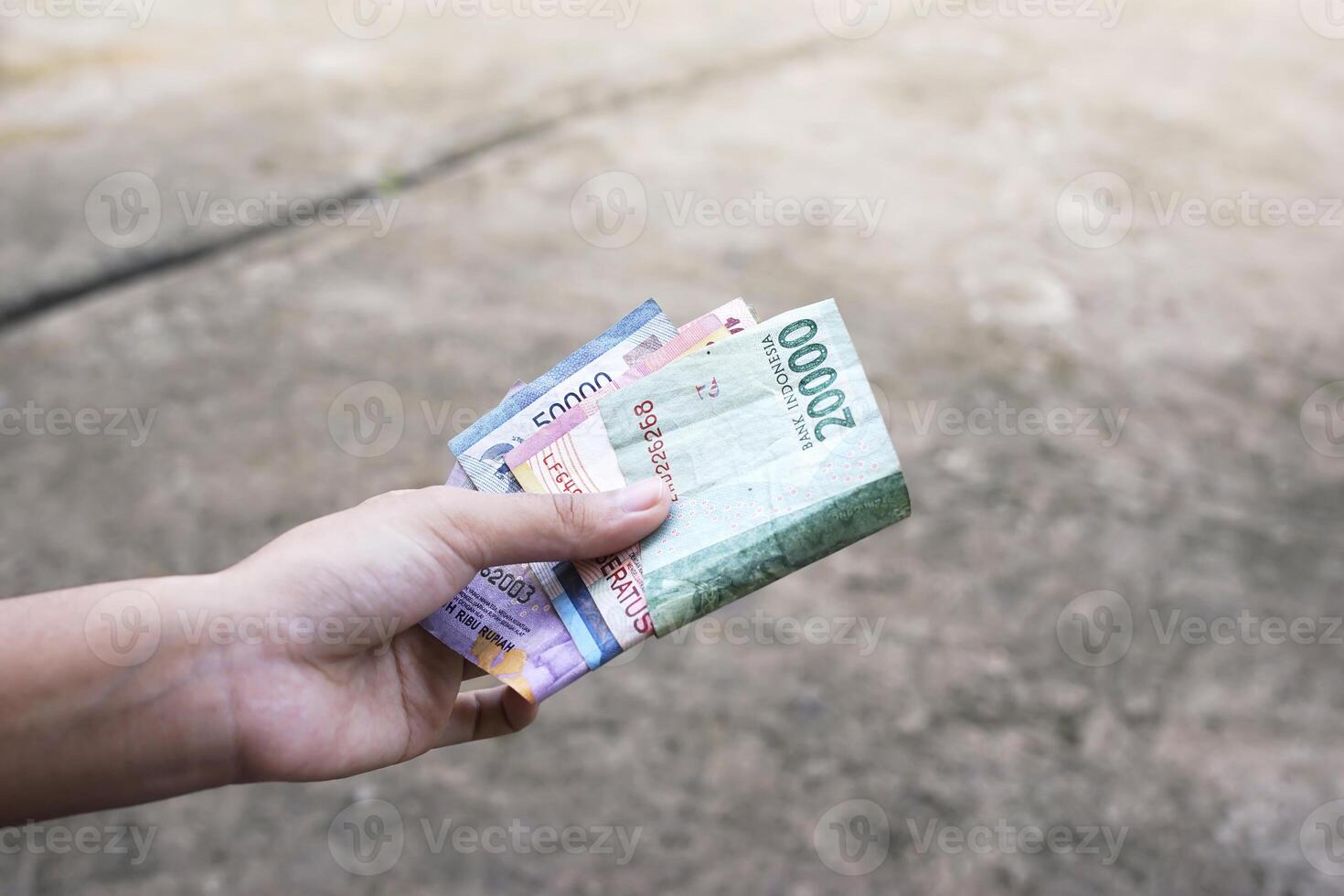 women show Indonesian money as a legal payment instrument photo