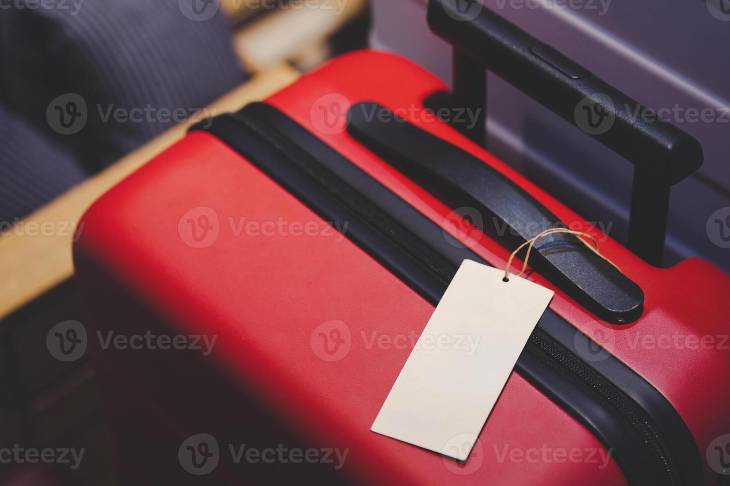 Red Suitcase with Blank Luggage Tag. Journeys, holidays, business trips, and new adventures. Perfect for travel agencies, booking platforms, or articles about packing and travel preparation. photo