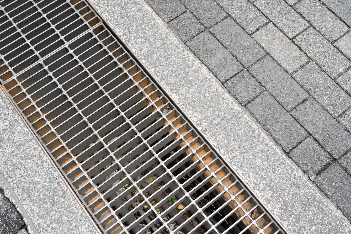 Urban Drainage Grate and Paving Stones. street and sidewalk design for water management and pedestrian areas. photo