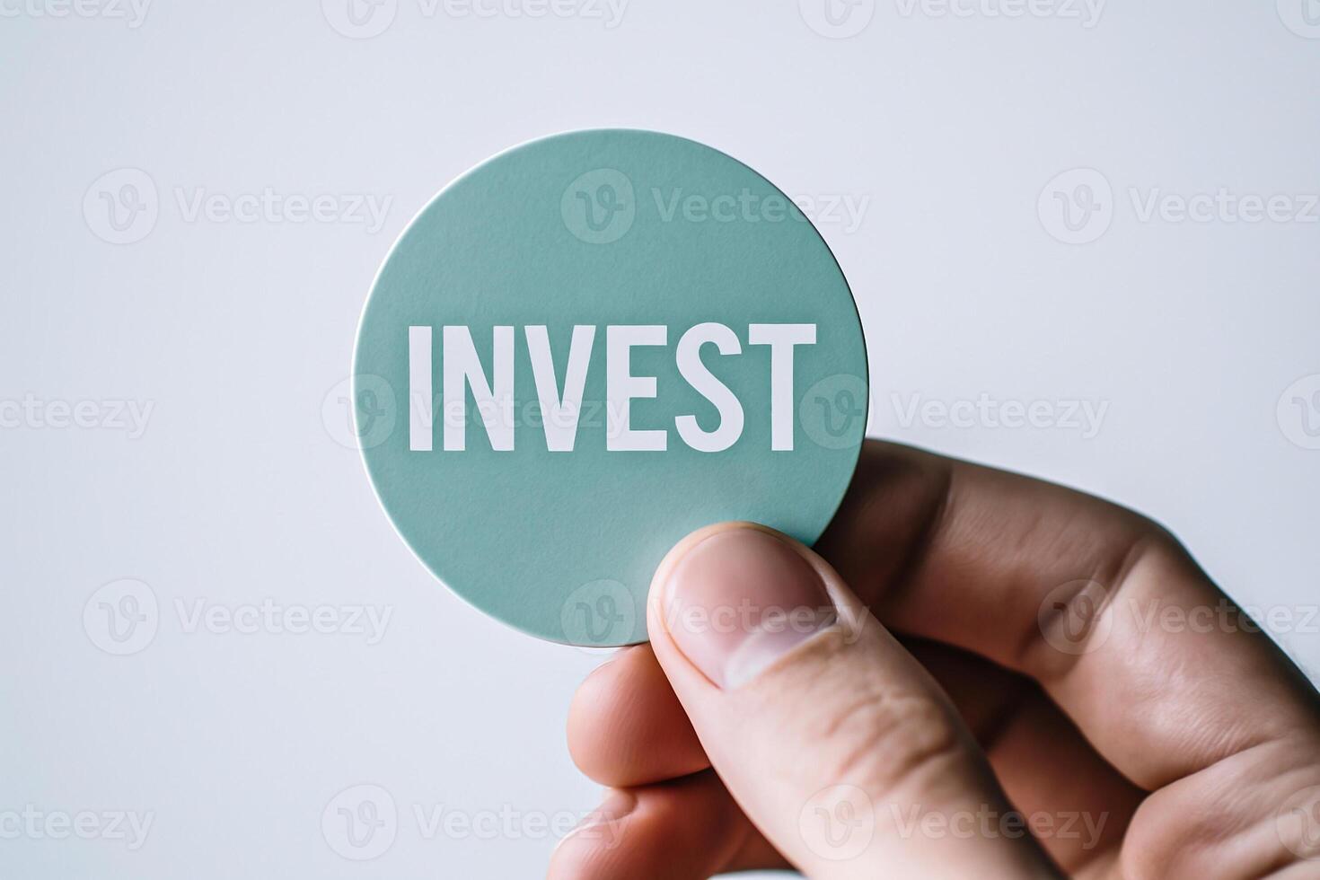 Male hand holding round green sticker with invest text, financial opportunity, economic strategy, capital planning and wealth generation concept photo