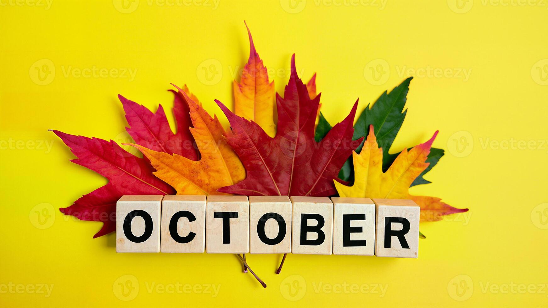 Autumn Leaves and cubes with word means 'October' on Yellow Background photo