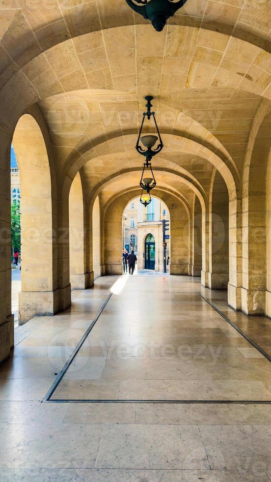 Stone Archway Corridor With Hanging Lamps photo