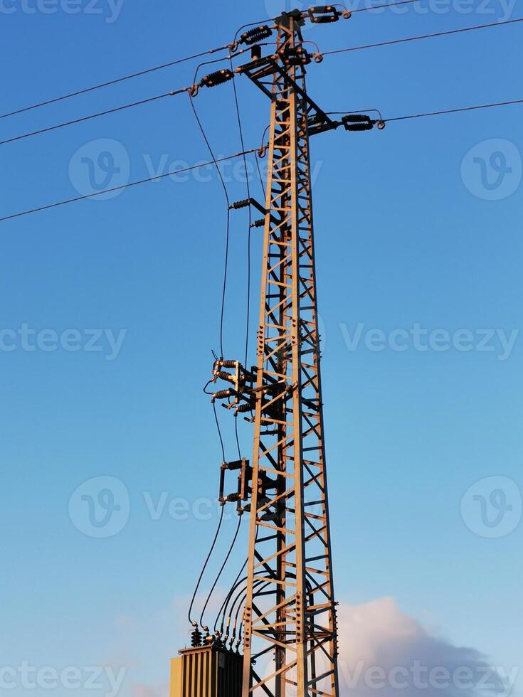 A tall power pole with wires on top photo