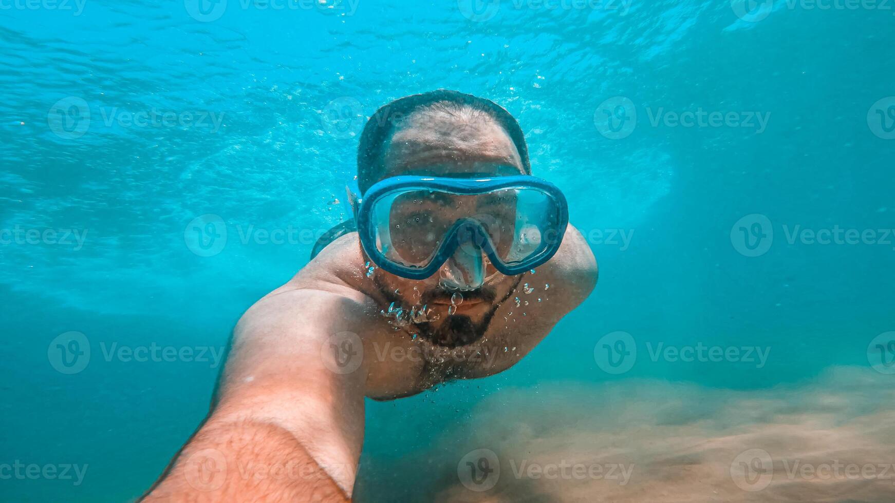 Man diving in water with a mask photo