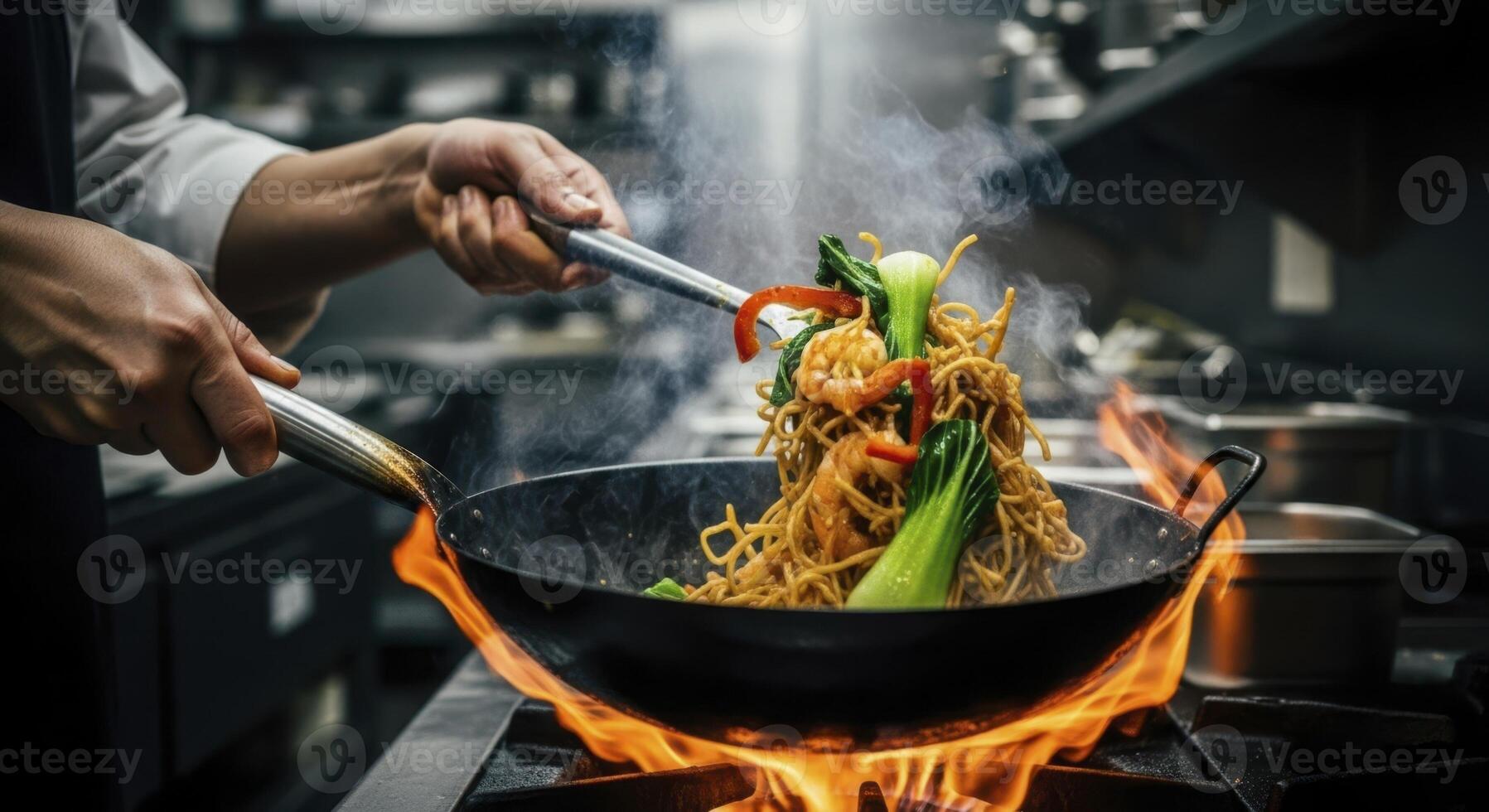 Professional chef stir frying asian noodles with vegetables and shrimp in a flaming wok photo