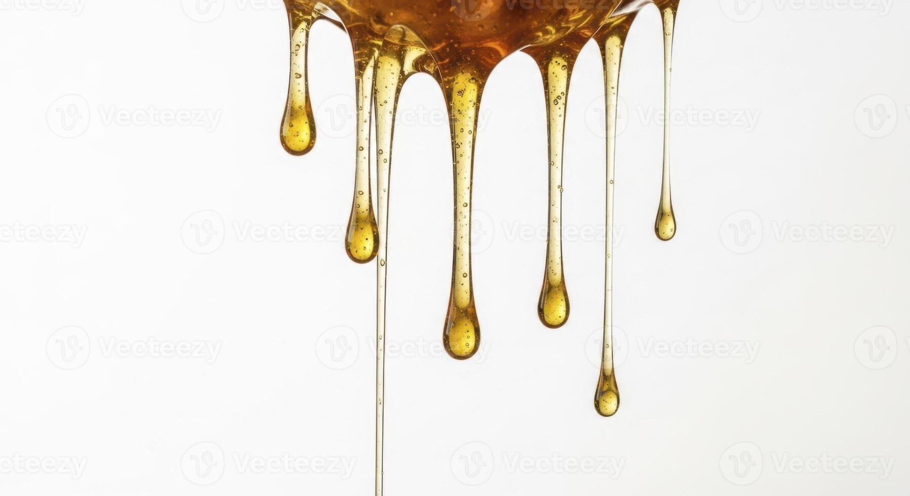 Close up of thick golden honey dripping against a pure white background photo