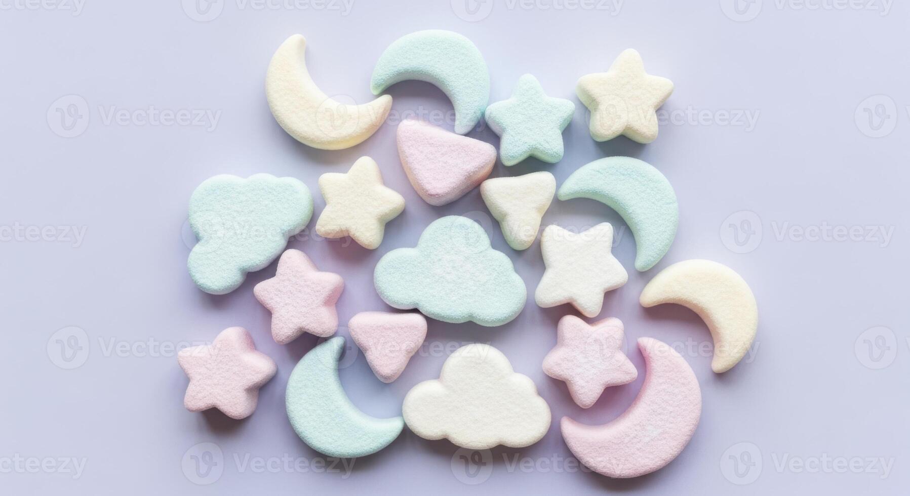 Pastel colored marshmallows in star, moon, and cloud shapes scattered on a light surface photo
