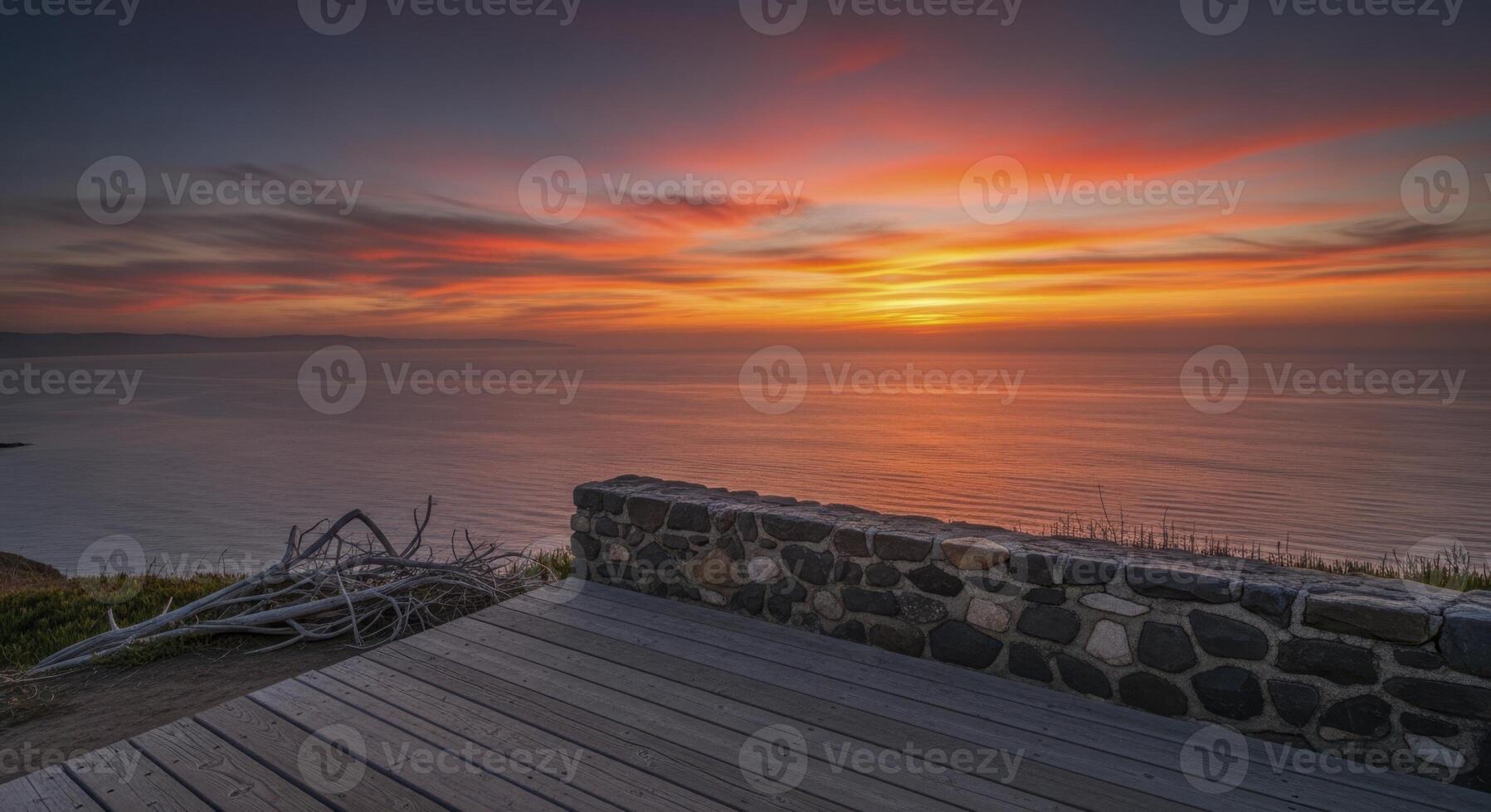 Vibrant sunset over serene ocean from cliffside observation deck photo