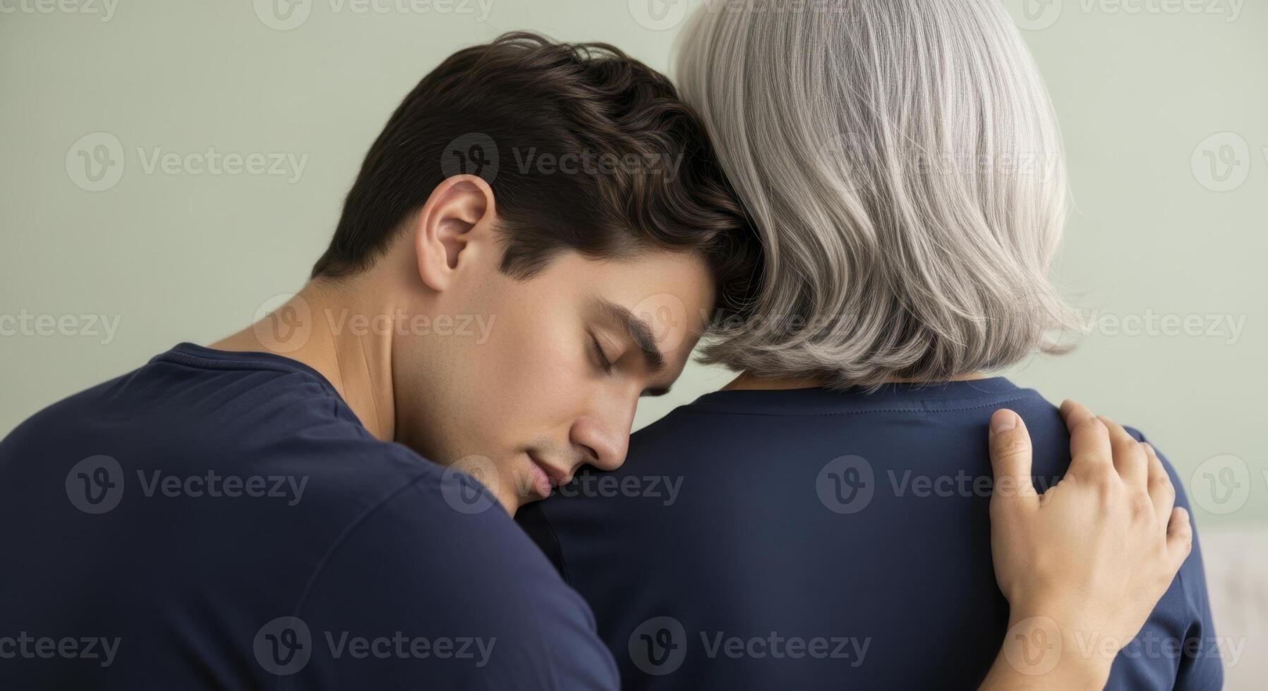 Adult son comforting his gray haired mother with a tender embrace and support photo