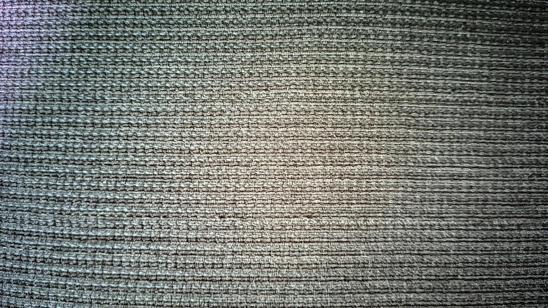 Detailed macro shot of a grey fabric, showcasing its complex weave and subtle variations in tone. The image emphasizes texture and pattern. photo