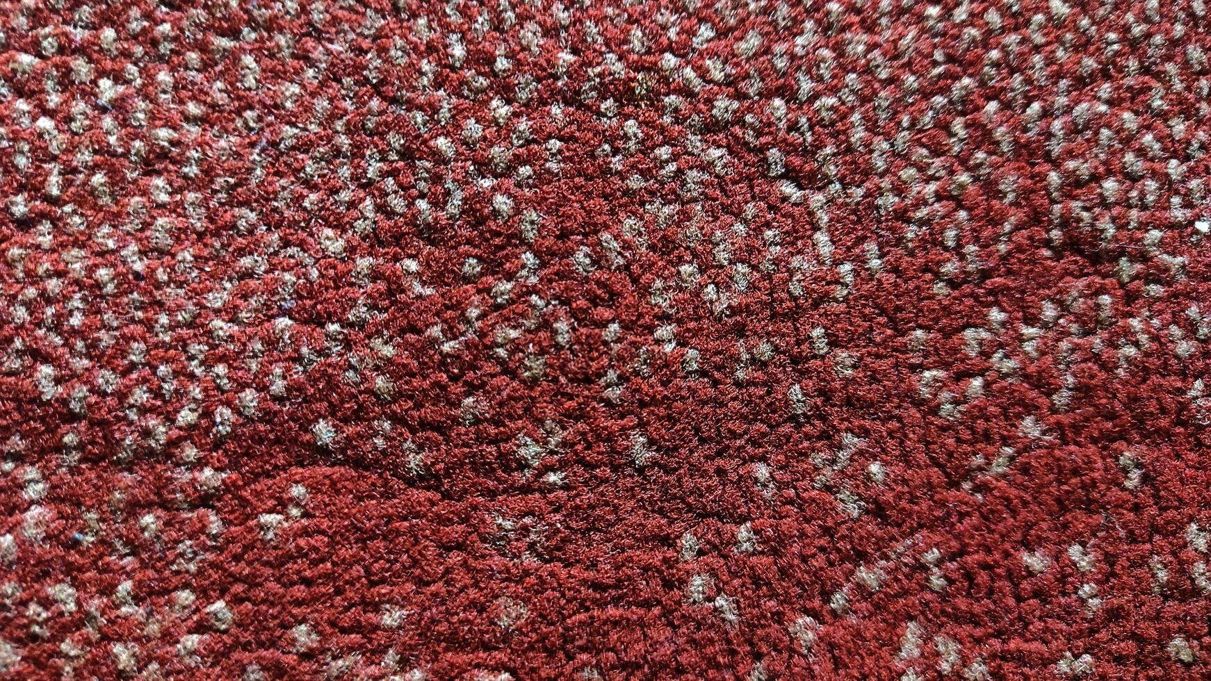 Intricate Red and Beige Textured Carpet Closeup - A Detailed Macro Shot Revealing the Woven Fibers and Pattern. photo