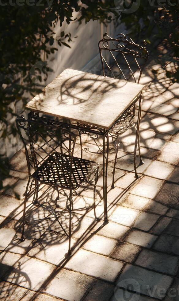 Sunlight dappled patio set creates an inviting outdoor ambiance with charming shadows and architectural details photo