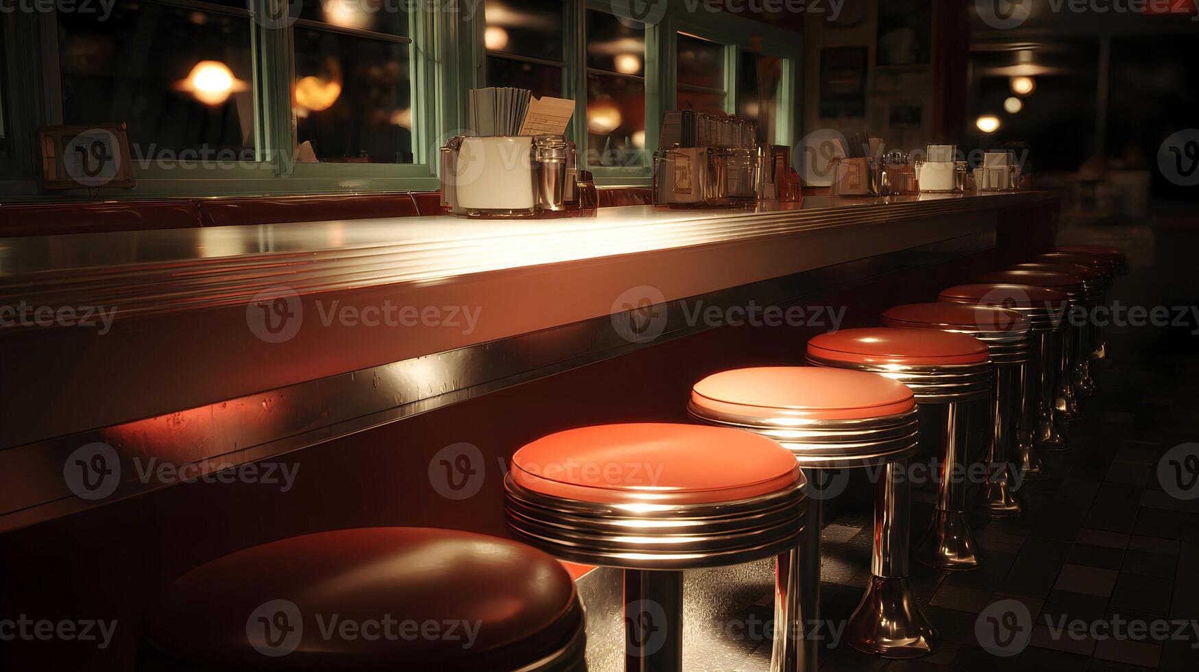 Retro diner scene featuring a row of chrome and orange swivel stools along a long countertop illuminated by warm lighting photo