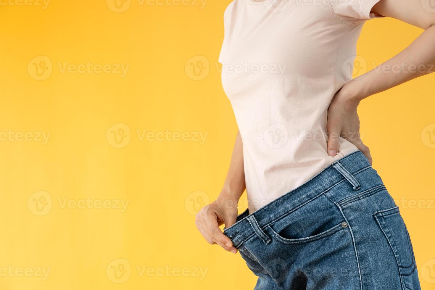 Women showing results of diet. Beautiful shape. female have a reduced waist size after under going a weight loss corse. can not wear jeans due to weight loss. balance, control, exercise. photo