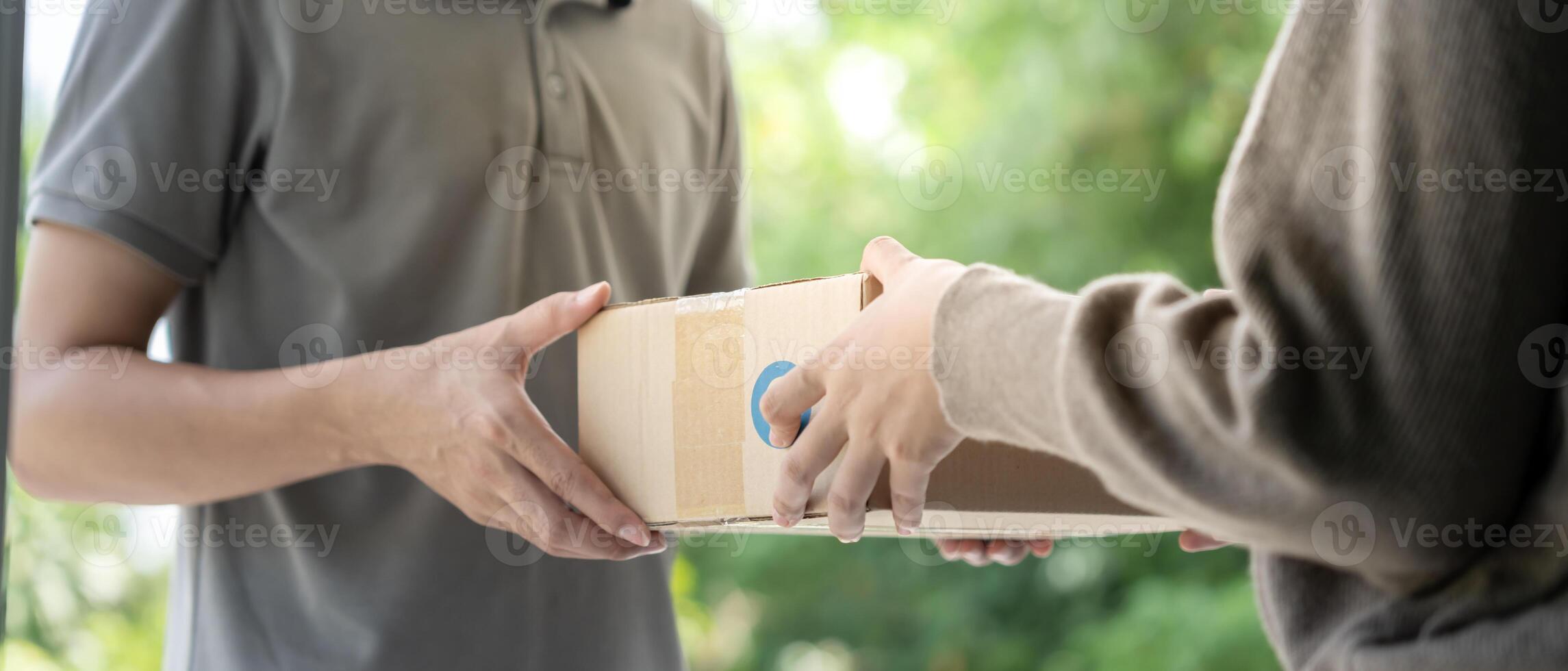 woman receives boxes parcel from courier in front house. Delivery man send deliver express. online shopping, paper containers, takeaway, postman, delivery service, packages. photo