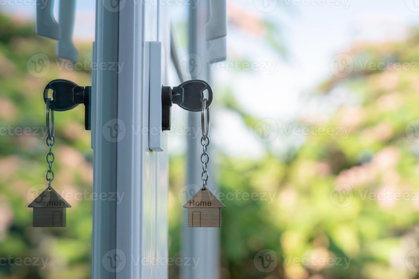 Landlord key for unlocking, house is plugged into the door. Second hand house for rent and sale. keychain is blowing in the wind. mortgage for new home, buy, sell, renovate, investment, owner, estate photo