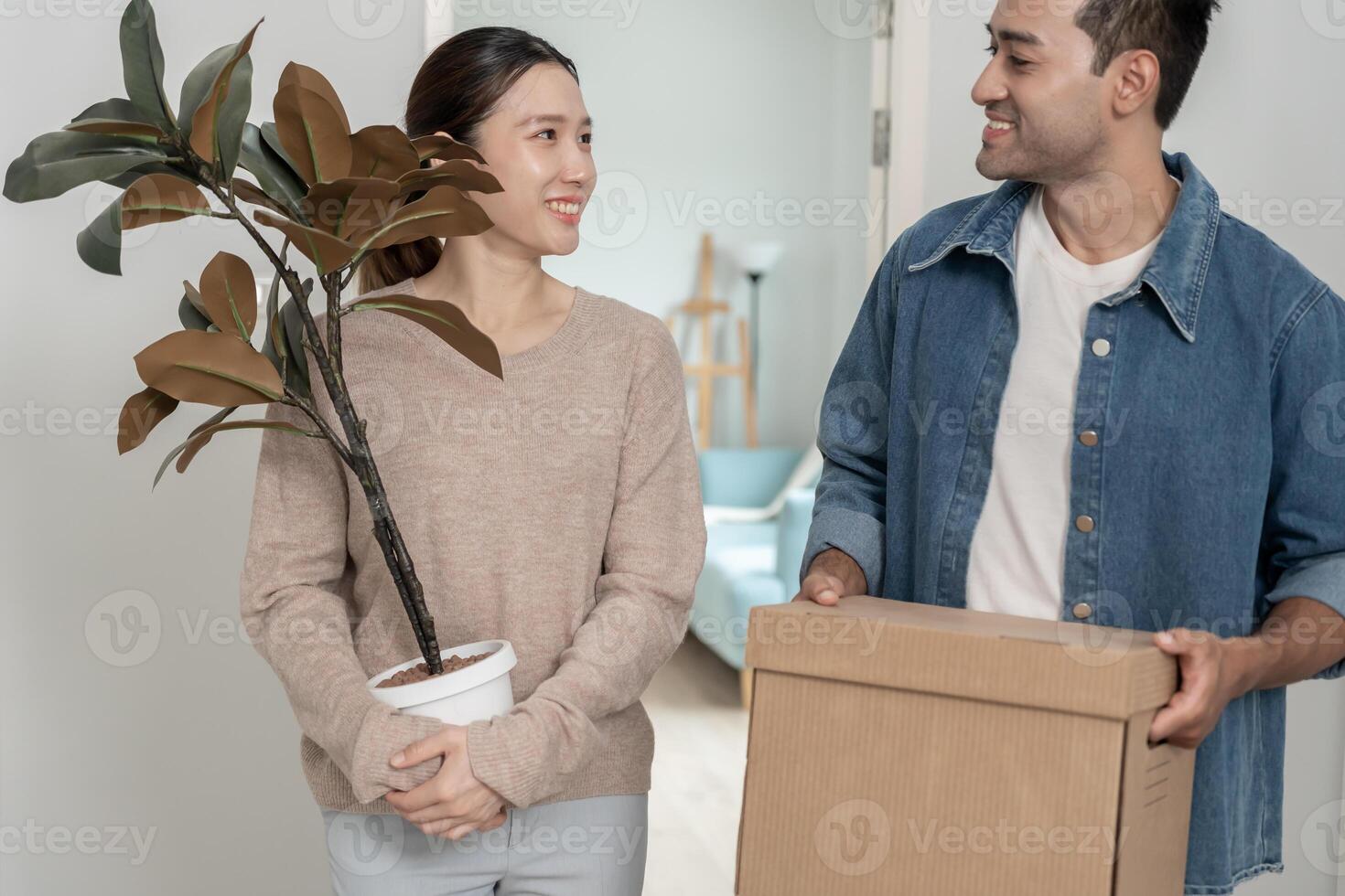Moving house, relocation. Couples hold carton box contain equipment for new condominium, inside the room was a cardboard box containing personal belongings and furniture. move in the apartment. photo