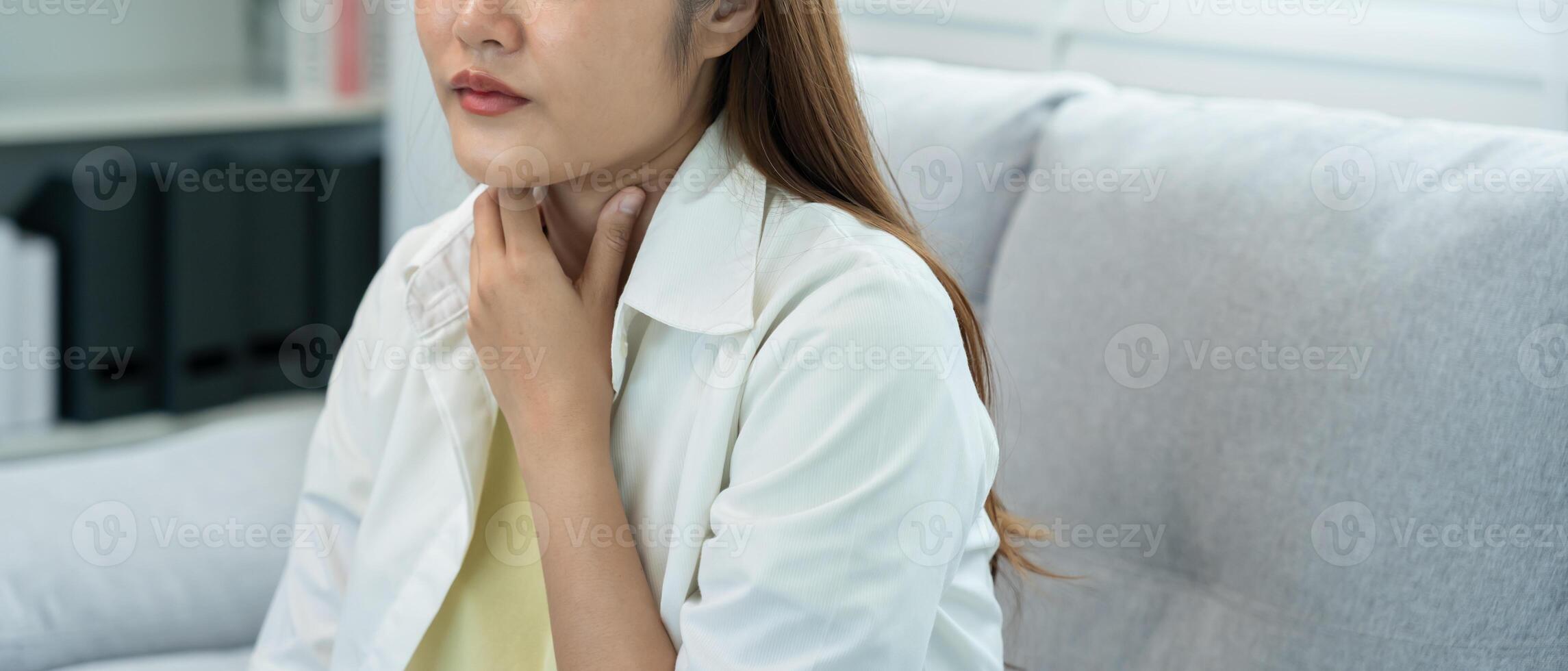 Asian woman put on neck due to a sore throat. female tonsillitis causes a inflammation. treated by taking water, taking antibiotics, consult a doctor, virus corona virus photo
