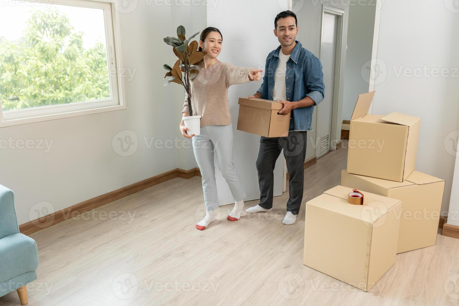 Moving house, relocation. Couples hold carton box and decorate contain equipment for new condominium, inside the room was a cardboard box containing personal belongings and furniture. moved apartment. photo