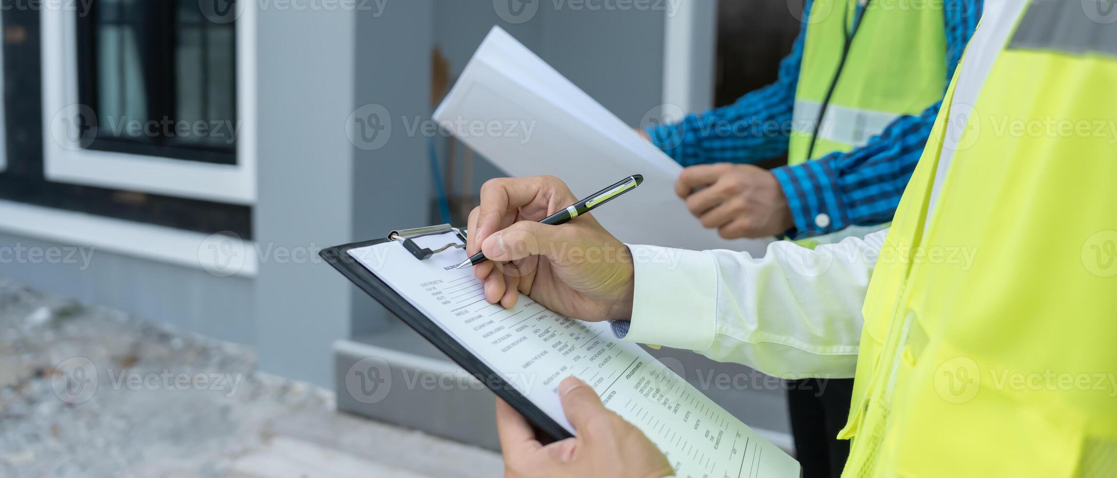 inspector or engineer is inspecting construction and quality assurance new house using a checklist. Engineers or architects or contactor work to build the house before handing it over the homeowner. photo