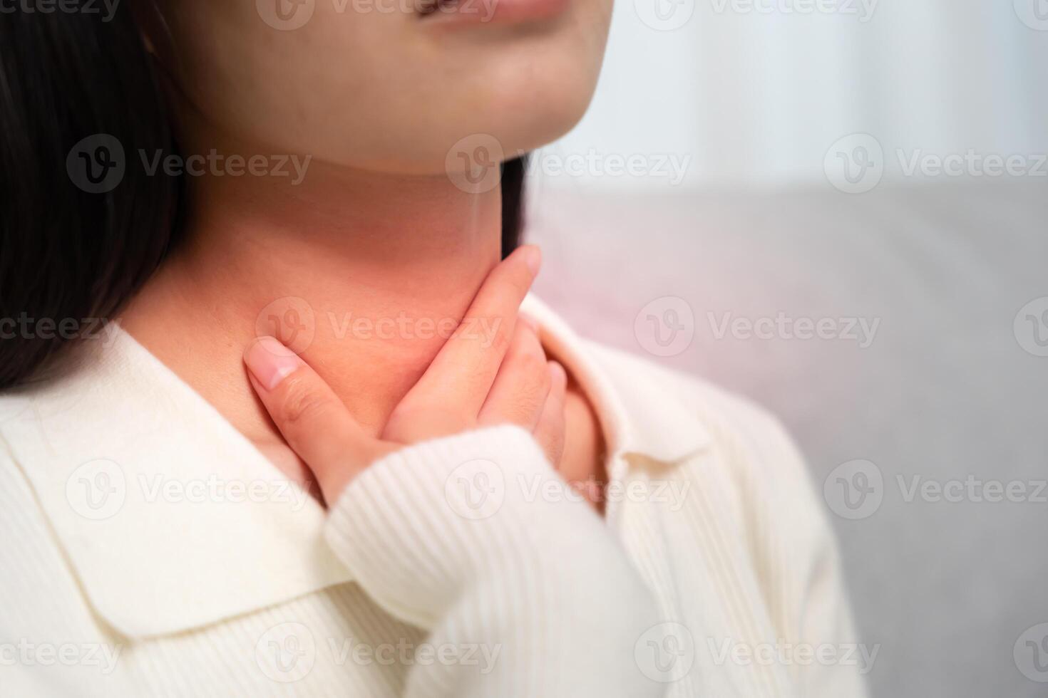 Asian woman put on neck due to a sore throat. female tonsillitis causes a inflammation. treated by taking water, taking antibiotics, consult a doctor, virus., Influenza, flu photo