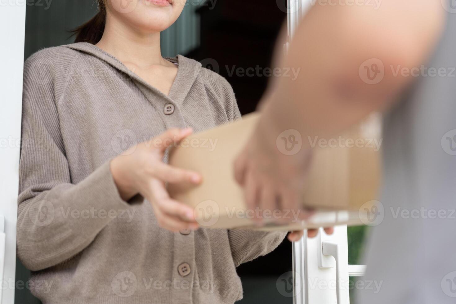 Happy smiling woman receives boxes parcel from courier in front house. Delivery man send deliver express. online shopping, paper containers, takeaway, postman, delivery service, package. photo