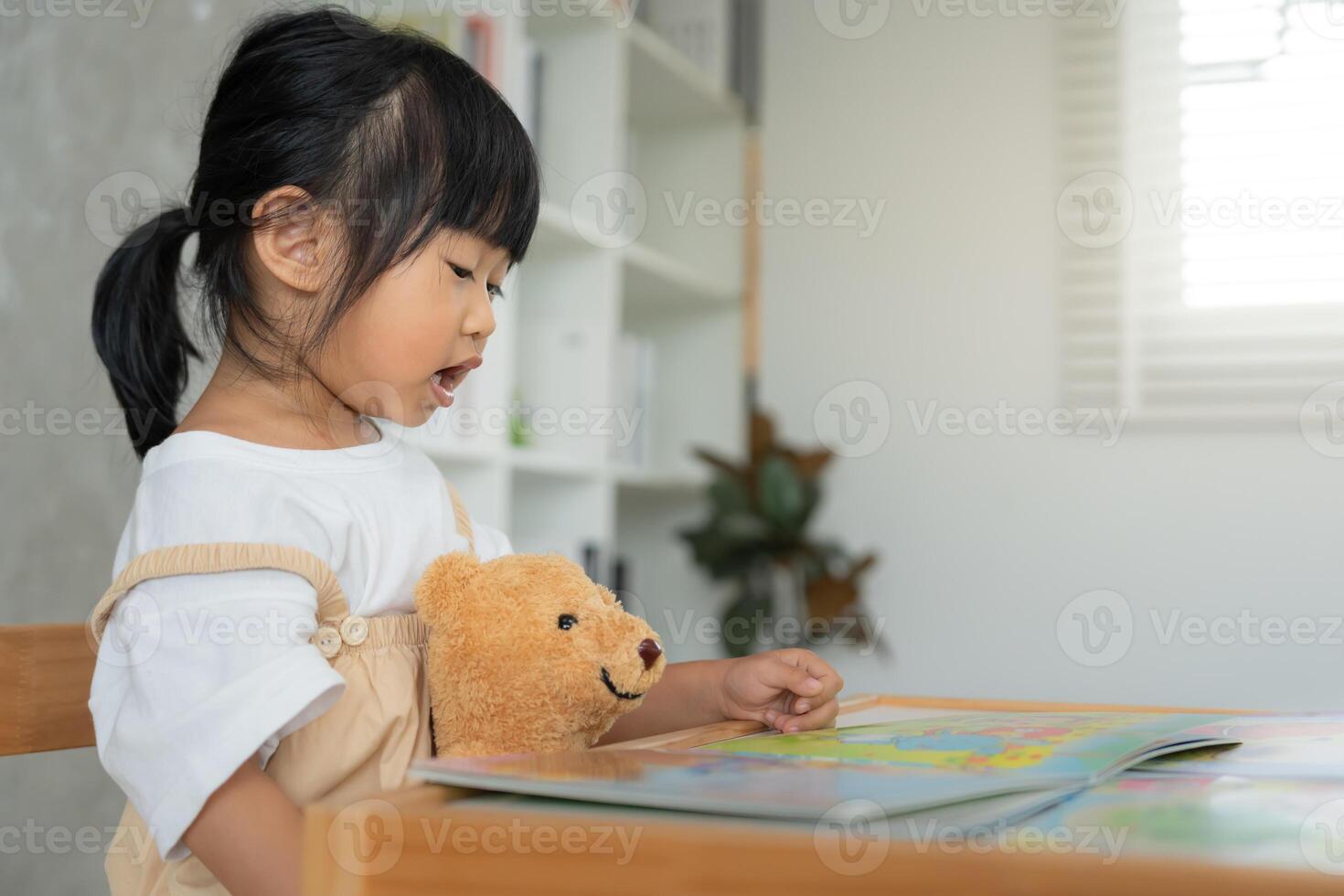 Happy Asian children relax read story book for bear doll. daughter and reading a story. learn development, childcare, education, storytelling, practice, imagine. photo