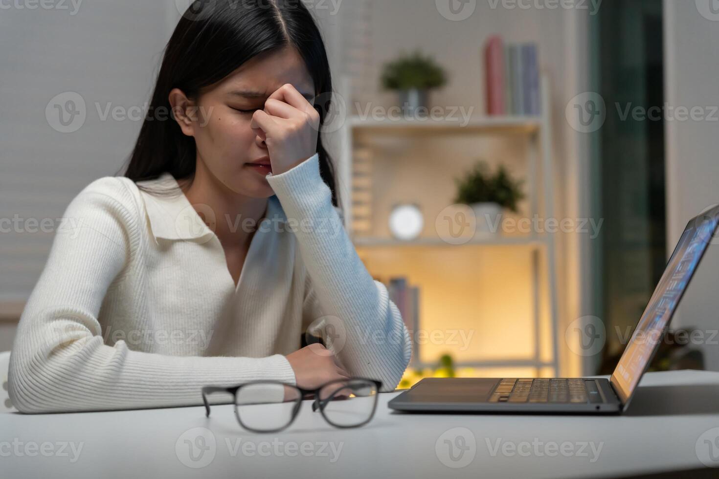 Eye problems, Asian women with tired and irritated eyes, eye rubbing, dry, eye pain after work, migraine, headache, blurred vision, photophobia, working in the dark. blue light from computer screen. photo